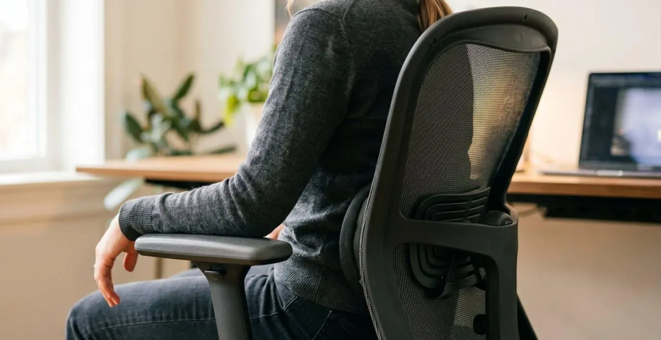 Détail du soutien lombaire ajustable d'une chaise ergonomique de bureau, avec indication visuelle de la zone de contact avec la colonne vertébrale